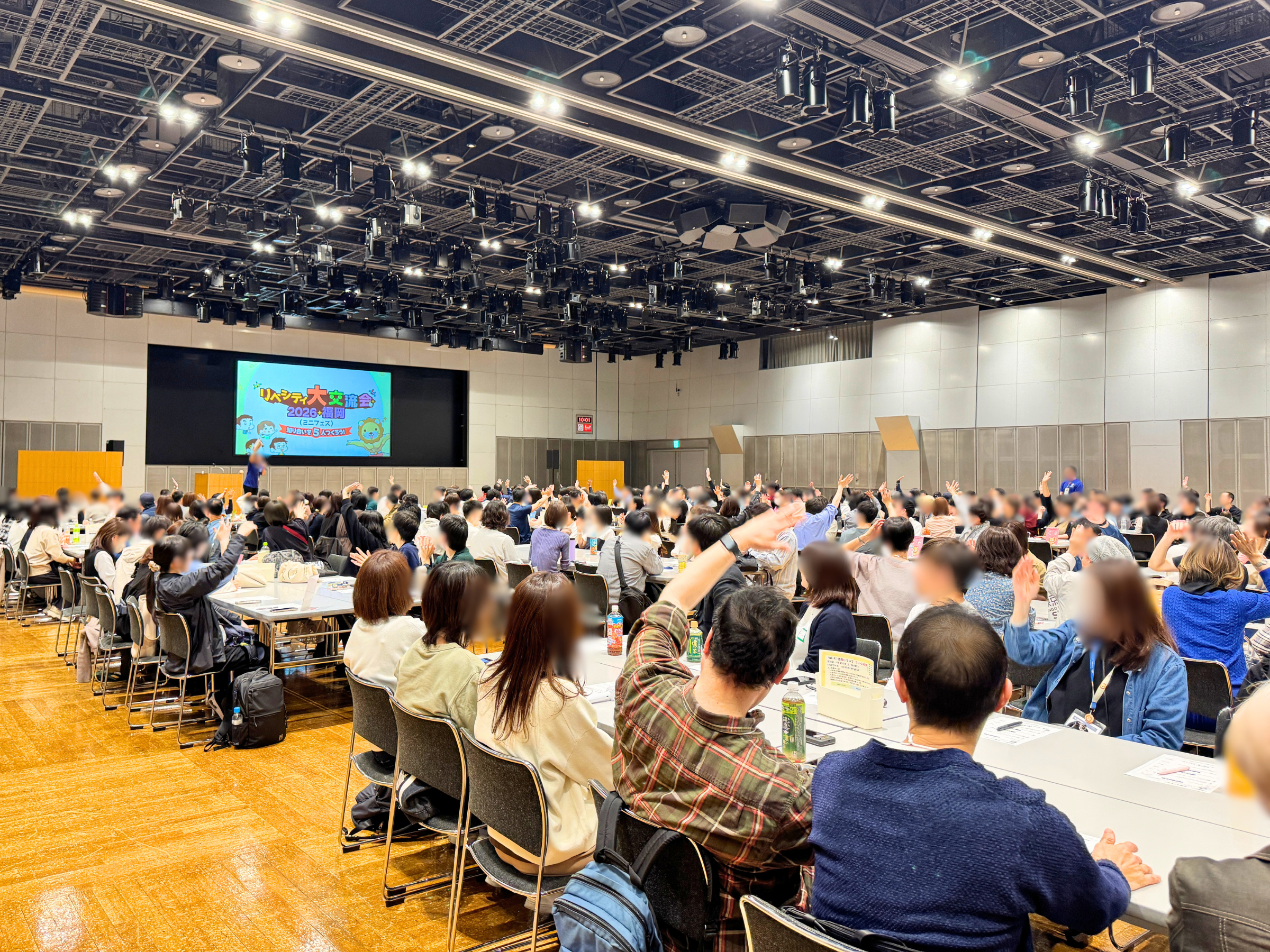 大交流会の会場で挙手する参加者のみなさん
