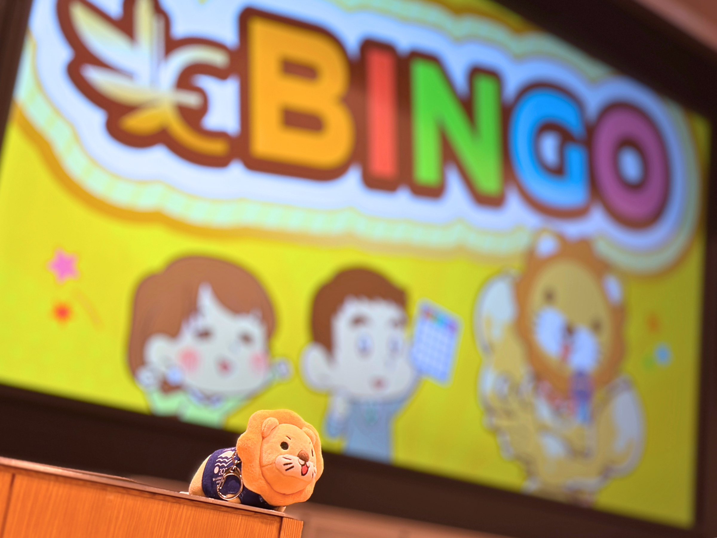 ビンゴ大会のスクリーンとリベシティのマスコット